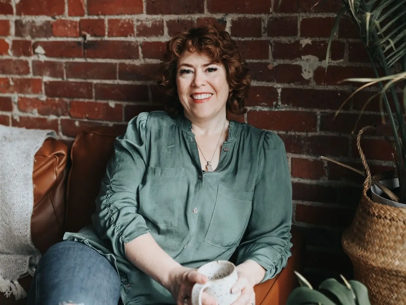 Erin seated in front of brick wall